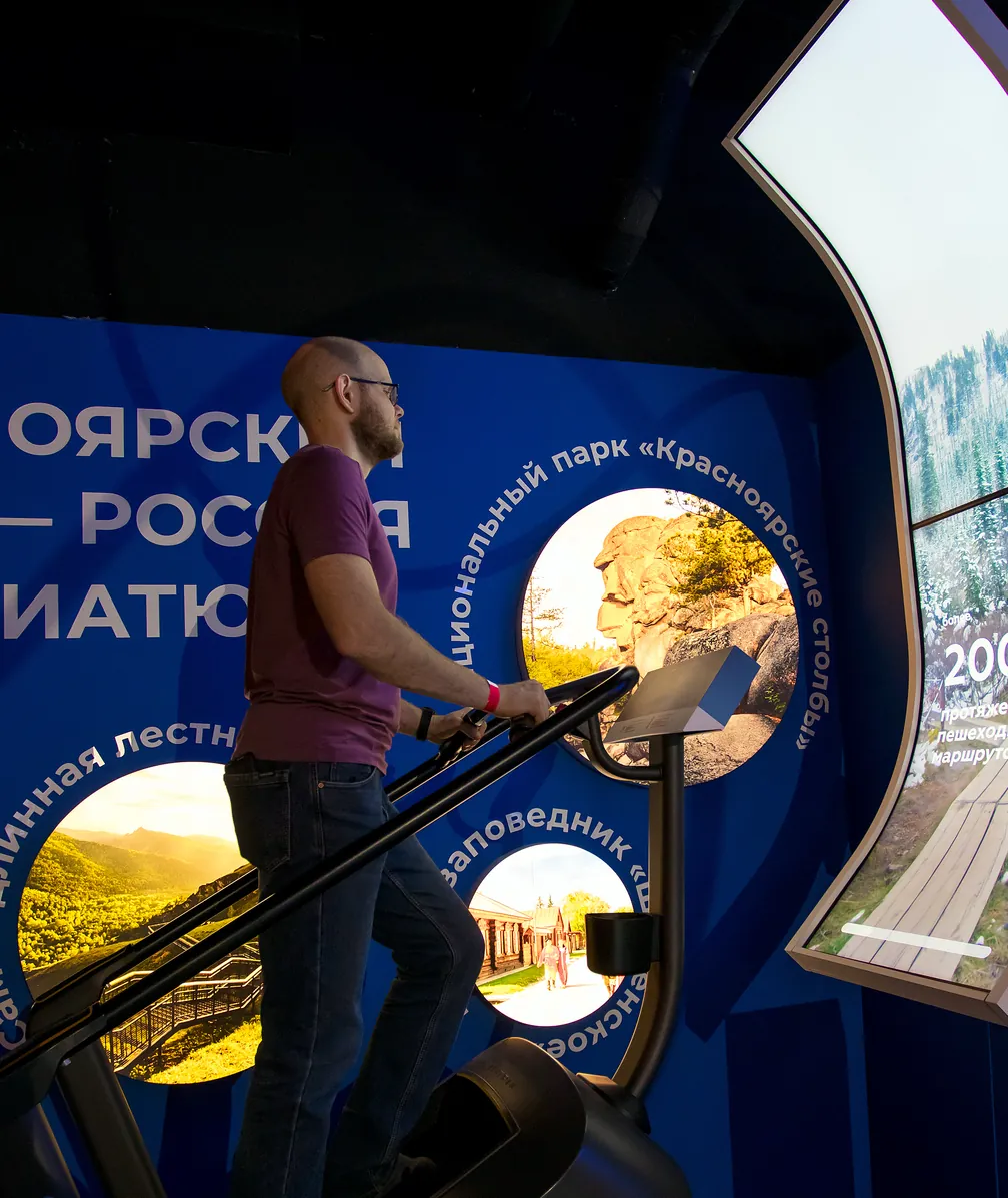 Посетитель на тренажёре в интерактивном пространстве